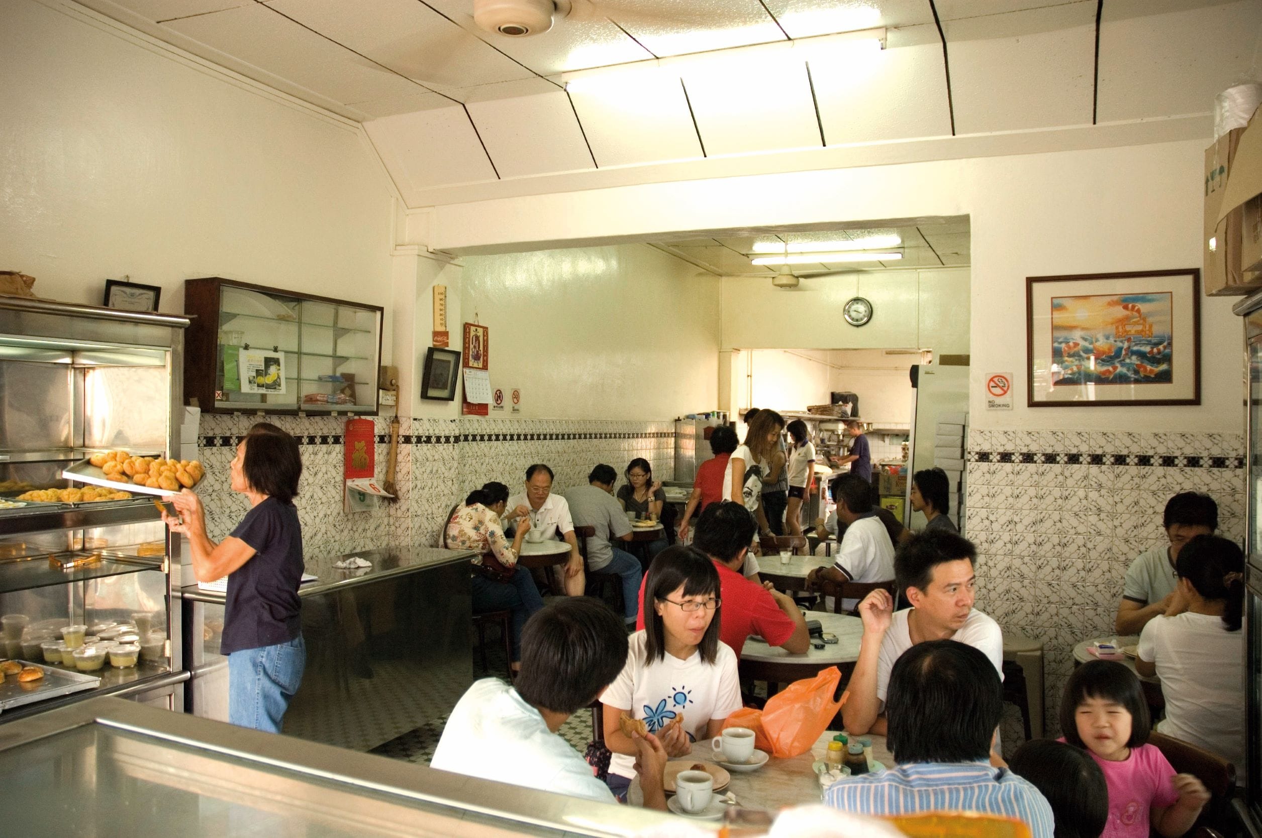 Customers young and old savour tempting treats as they soak in the old-world charm of the coffee shop which retains its original mosaic tiles, charcoal toasters and old ceiling fans from the 1970s.